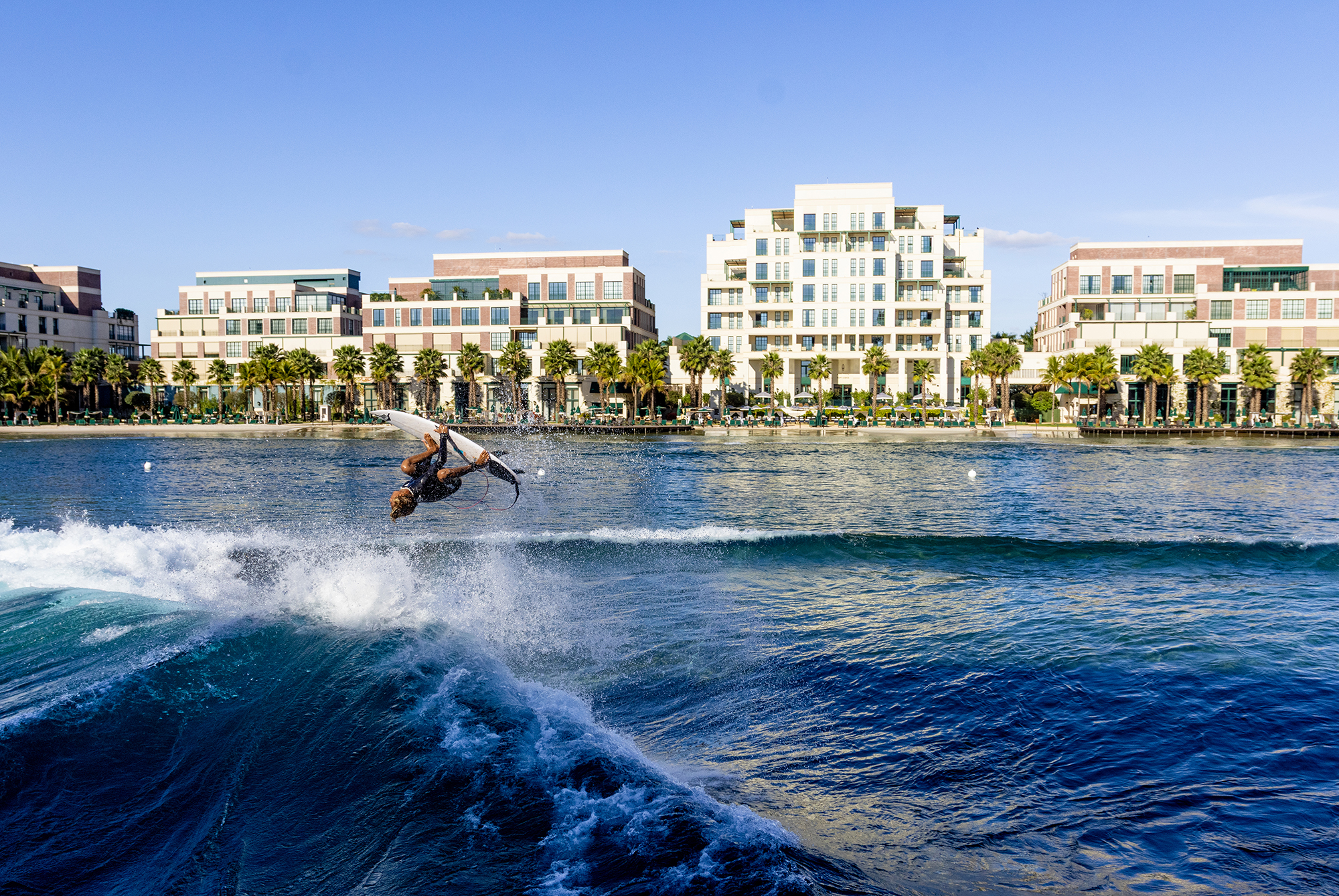 Surfer backflips in front of the perfectswell boa vista apartments