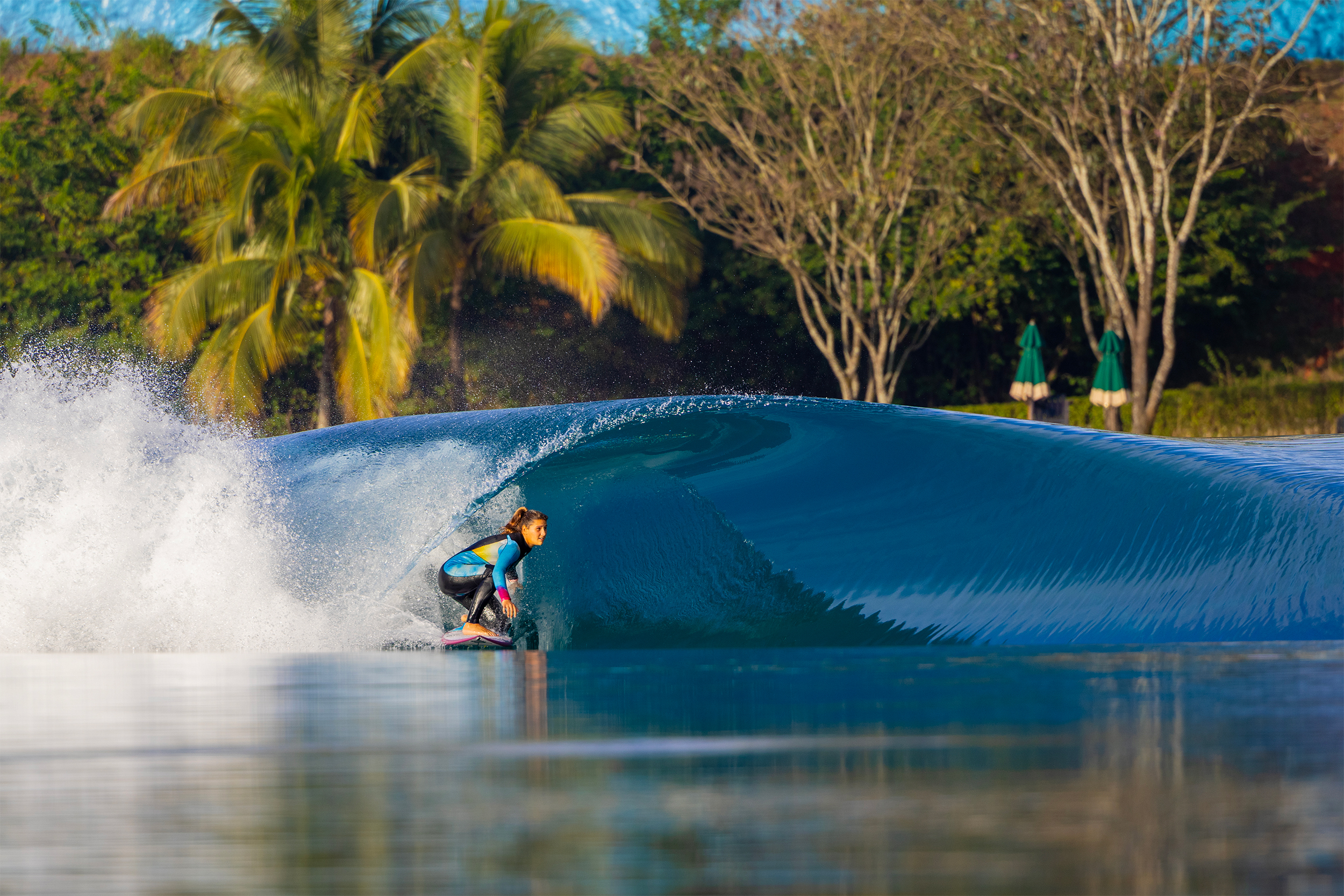 Female surfer on a glassy perfectswell peeling wave.